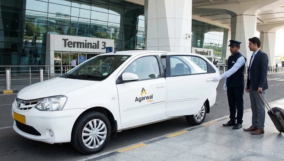 an agarwal cabs chauffeur opens the door of a white taxi for a business traveler outside indira gandhi international airport (igi) terminal 3 in delhi.