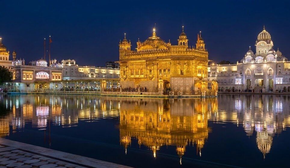 night view of the illuminated golden temple (harmandir sahib) in amritsar with its reflection in the amrit sarovar pool.